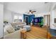 Bright living room featuring hardwood floors, a large sectional sofa, and lots of natural light from the windows at 440 42Nd N St, St Petersburg, FL 33713