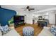 Comfortable living room featuring a fan, wood floors, muraled accent wall, and kitchen view at 440 42Nd N St, St Petersburg, FL 33713