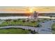 Aerial view featuring modern building at sunset by a waterway, with surrounding greenery and parking at 4696 Del Sol Blvd, Sarasota, FL 34243