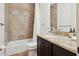 Well-lit bathroom featuring a granite countertop, shower-tub combo, and neutral earth-tone tile at 4696 Del Sol Blvd, Sarasota, FL 34243