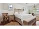 Bright and airy main bedroom with a large bed, wood floors, a comfortable sitting area, and large windows at 4696 Del Sol Blvd, Sarasota, FL 34243