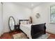 Clean and well lit bedroom featuring hardwood floors, accent rug, dark wood furniture, and plenty of natural light at 4696 Del Sol Blvd, Sarasota, FL 34243