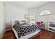 Cozy bedroom featuring hardwood floors, a comfortable bed, and an arched window for natural light at 4696 Del Sol Blvd, Sarasota, FL 34243