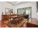 Formal dining room with a large wooden table, chandelier, and sliding glass doors to an outdoor patio at 4696 Del Sol Blvd, Sarasota, FL 34243
