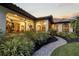 Beautifully landscaped exterior with a brick walkway leading to the arched entrance of this charming home at 4696 Del Sol Blvd, Sarasota, FL 34243