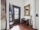 Entry foyer with hardwood floors, decorative mirror, front door and coat rack at 4696 Del Sol Blvd, Sarasota, FL 34243