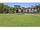 Beautiful Mediterranean-style home featuring lush landscaping, a manicured lawn, and a charming blue fountain at 4696 Del Sol Blvd, Sarasota, FL 34243
