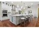 Modern kitchen with gray island, white cabinets, stainless steel appliances, and pendant lighting at 4696 Del Sol Blvd, Sarasota, FL 34243