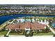 Aerial view of a community clubhouse with a pool, lake, and scenic surroundings in a residential area at 4988 Fairhope Cir, Lakewood Ranch, FL 34211