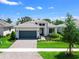 Beautiful single-story home featuring a gray roof, lush landscaping, and a two-car garage at 4988 Fairhope Cir, Lakewood Ranch, FL 34211