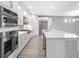 Modern kitchen with stainless steel appliances, sleek white cabinets, and large center island with marble countertop at 4988 Fairhope Cir, Lakewood Ranch, FL 34211