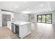 Open kitchen with stainless appliances, island with seating, and sliding glass doors leading to pool at 4988 Fairhope Cir, Lakewood Ranch, FL 34211