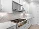 Gourmet kitchen with stainless steel range, herringbone backsplash, white cabinets, and white countertops at 4988 Fairhope Cir, Lakewood Ranch, FL 34211