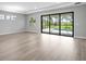 Bright, open living room with hardwood floors and sliding glass doors to the pool area at 4988 Fairhope Cir, Lakewood Ranch, FL 34211