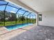 Screened outdoor pool and patio without furniture, with views of the lush greenery and landscaping at 4988 Fairhope Cir, Lakewood Ranch, FL 34211