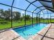 Sparkling pool inside screened enclosure, surrounded by lush green lawns and views, perfect for relaxing or entertaining at 4988 Fairhope Cir, Lakewood Ranch, FL 34211