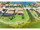 Expansive aerial view of the homes along a lake, showcasing well-manicured lawns and waterfront access at 501 Maraviya Blvd, Nokomis, FL 34275