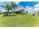Lush green backyard featuring a charming stone bridge and picturesque waterfront views at 501 Maraviya Blvd, Nokomis, FL 34275