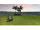 Tranquil backyard with lake views, mature trees, a grassy lawn, and outdoor seating at 501 Maraviya Blvd, Nokomis, FL 34275