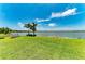 Expansive backyard with lush green lawn, waterfront views, and dock with chairs for serene relaxation at 501 Maraviya Blvd, Nokomis, FL 34275