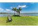 Lush backyard with palm trees and scenic waterfront views provides a perfect tranquil escape at 501 Maraviya Blvd, Nokomis, FL 34275