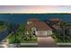 Beautiful waterfront home with manicured landscaping and a classic tile roof at sunset at 501 Maraviya Blvd, Nokomis, FL 34275