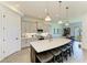 Open kitchen boasts a large island with seating, pendant lights, and modern appliances at 501 Maraviya Blvd, Nokomis, FL 34275
