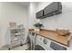 Organized laundry room with counter space, shelving, and modern washer and dryer appliances at 501 Maraviya Blvd, Nokomis, FL 34275