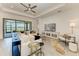 Bright living room featuring a ceiling fan, TV, comfortable seating, and water views at 501 Maraviya Blvd, Nokomis, FL 34275