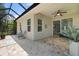 Covered patio with brick floors, ceiling fan and sliding glass doors to the home's interior at 5047 Newport News Cir, Bradenton, FL 34211