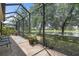 Screened-in lanai offers a tranquil view of the water and lush landscaping, perfect for relaxing at 5047 Newport News Cir, Bradenton, FL 34211