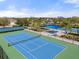 Close-up of a tennis court with lush landscaping and covered seating in a great community at 5047 Newport News Cir, Bradenton, FL 34211