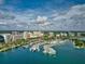 Aerial view of a marina with boats docked in the sparkling blue water, and city skyline at 5074 Flagstone Dr, Sarasota, FL 34238