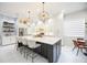Elegant kitchen with a large center island, pendant lighting, white cabinetry, and stainless steel appliances at 5074 Flagstone Dr, Sarasota, FL 34238