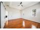 Spacious main bedroom with hardwood floors, two windows, white trim and tray ceiling with modern fan at 5074 Flagstone Dr, Sarasota, FL 34238