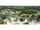 Aerial view of a residential community, surrounded by lush greenery, a pond, and a golf course at 5240 Silver Charm Ter, Wesley Chapel, FL 33544