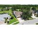 An aerial view shows a home with a tile roof, manicured lawn, and an attached two-car garage near a golf course at 5240 Silver Charm Ter, Wesley Chapel, FL 33544