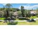 View of a well-maintained backyard with mature trees, a screened patio and a golf cart at 5240 Silver Charm Ter, Wesley Chapel, FL 33544