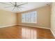 Bedroom featuring hardwood floors, yellow walls, and a window with shutter blinds at 5240 Silver Charm Ter, Wesley Chapel, FL 33544