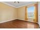 Bedroom with wood floors and a large window with curtains for a comfy feel at 5240 Silver Charm Ter, Wesley Chapel, FL 33544