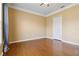 Bedroom featuring hardwood floors, double closets, and a window with blue curtain and yellow walls at 5240 Silver Charm Ter, Wesley Chapel, FL 33544