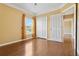 A bedroom featuring hardwood floors, double closets, and a window with curtains at 5240 Silver Charm Ter, Wesley Chapel, FL 33544