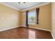 Bedroom featuring hardwood floors, crown molding, a window with blinds, and light yellow walls at 5240 Silver Charm Ter, Wesley Chapel, FL 33544