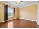 Bright room with hardwood floors, crown molding, a window with blinds, and light yellow walls at 5240 Silver Charm Ter, Wesley Chapel, FL 33544