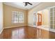 Bright and airy room with hardwood floors and a ceiling fan, adjacent to the main entrance at 5240 Silver Charm Ter, Wesley Chapel, FL 33544