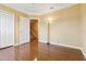 Bright bedroom featuring hardwood floors, crown molding, closet, and an open doorway at 5240 Silver Charm Ter, Wesley Chapel, FL 33544