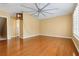 Bedroom featuring hardwood floors, yellow walls, and a window with shutter blinds and fan at 5240 Silver Charm Ter, Wesley Chapel, FL 33544