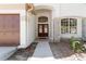 Inviting entryway with double doors, a stone-accented facade, and a glimpse of the home's bright interior at 5240 Silver Charm Ter, Wesley Chapel, FL 33544