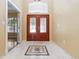 Welcoming foyer with elegant tile flooring, double doors, and high ceilings, creating a grand entrance at 5240 Silver Charm Ter, Wesley Chapel, FL 33544