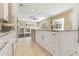 Bright kitchen features white cabinetry, granite countertops, and opens to an airy living space with natural light at 5240 Silver Charm Ter, Wesley Chapel, FL 33544